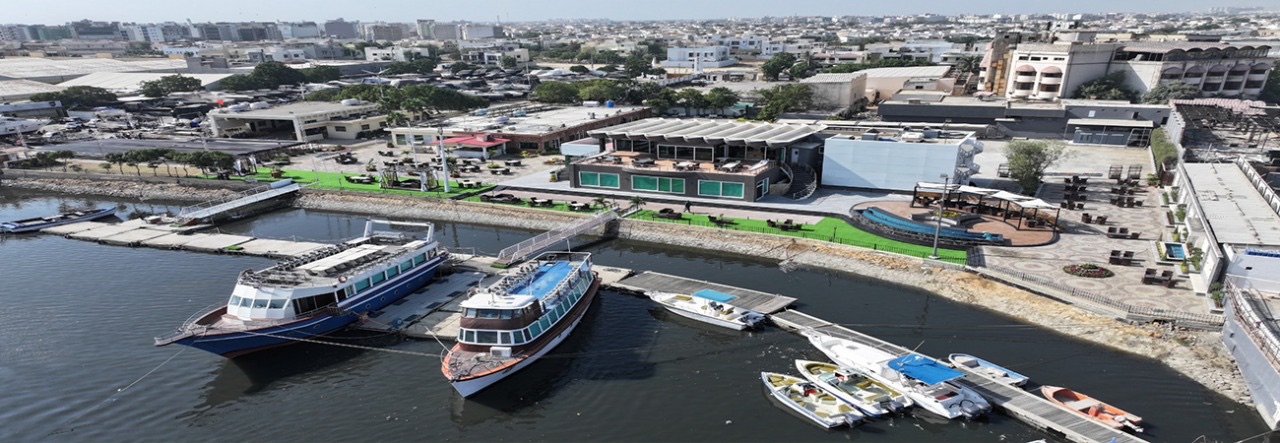 DHA Marina Club’s waterfront, with boats moored in front of the clubhouse